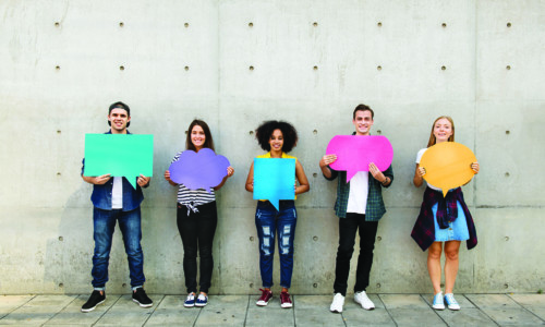 Group of young adults outdoors holding empty placard copy-space thought bubbles